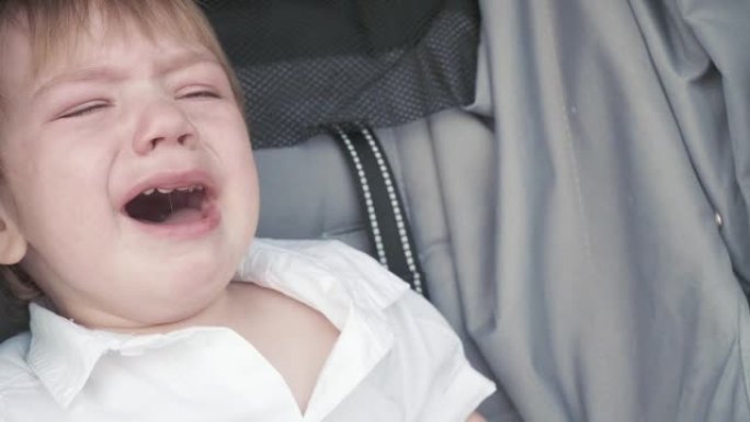 男孩在骑婴儿车中哭泣