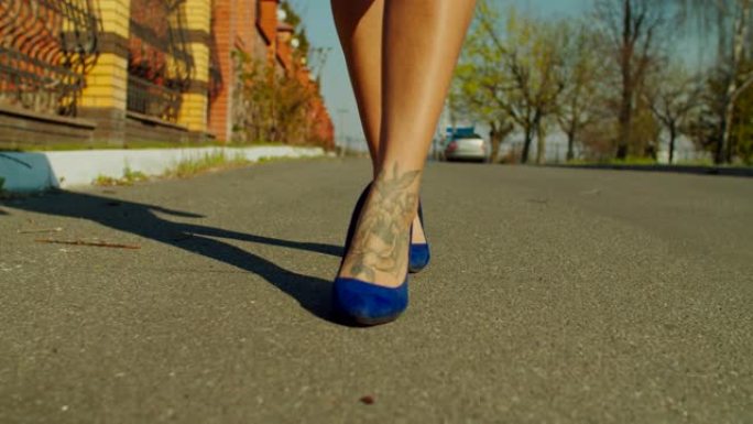 穿着细高跟鞋走在街上的女性腿