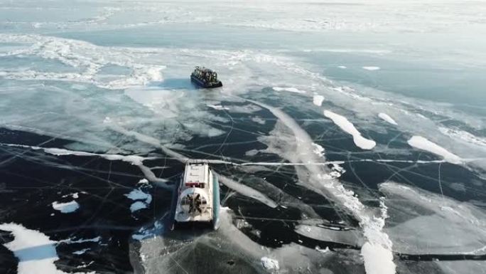 贝加尔湖的船艇乘坐透明的蓝色冰原贝加尔湖。如画的太阳反射出独特的裂缝。俄罗斯冬季旅游胜地。高空高空