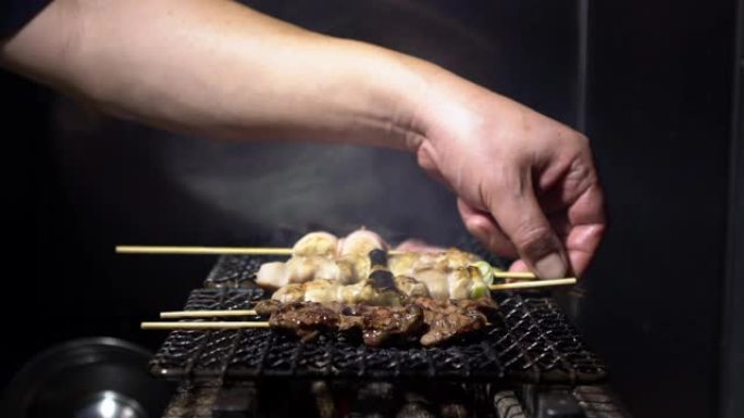 东京居酒屋日本酒吧内厨师烹饪的慢动作。日本食品