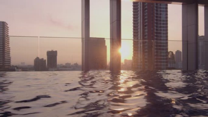 阳光透过摩天大楼进入无边泳池