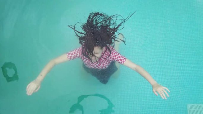 年轻女孩沉入游泳池