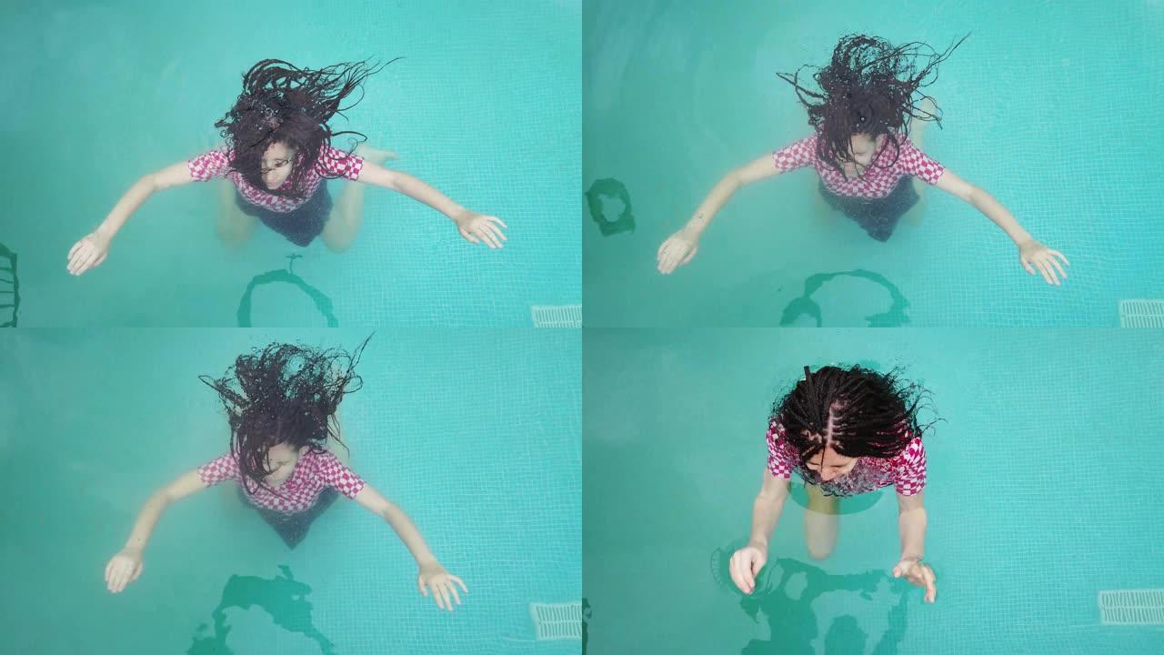 年轻女孩沉入游泳池