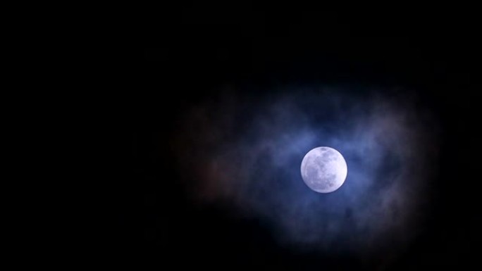 夜空中的冷月回到柔软而黑暗的云层移动通过