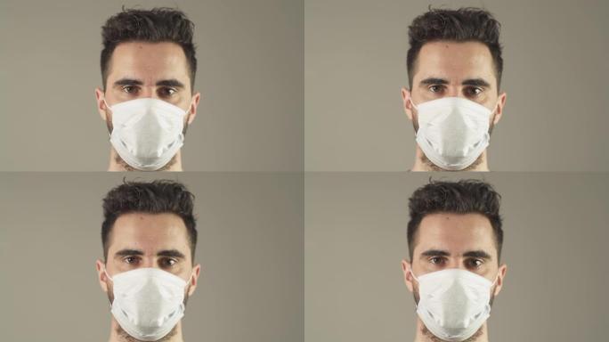 在法国新型冠状病毒肺炎大流行病毒期间，戴着外科口罩、棕色头发和眼睛的孤立男子面对工作室的镜头。4K 