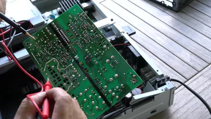电工修理有故障的音响设备。用万用表测试印刷电路板、印刷电路板上的电流