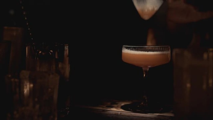 泰国曼谷一家酒吧的酒保准备鸡尾酒的实时特写镜头。大城市的夜生活
