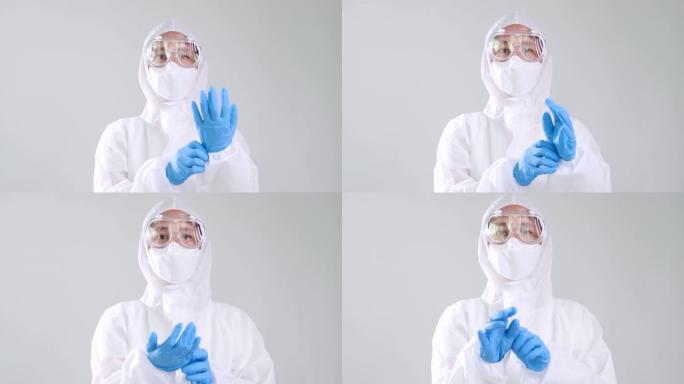 穿着防护危险品PPE套装的亚洲医生戴着医用乳胶手套，慢动作镜头