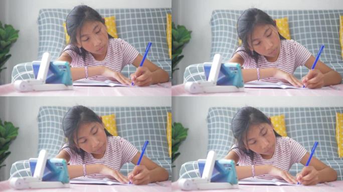 亚洲女孩从家里学习智能手机，家庭教育期间新型冠状病毒肺炎。