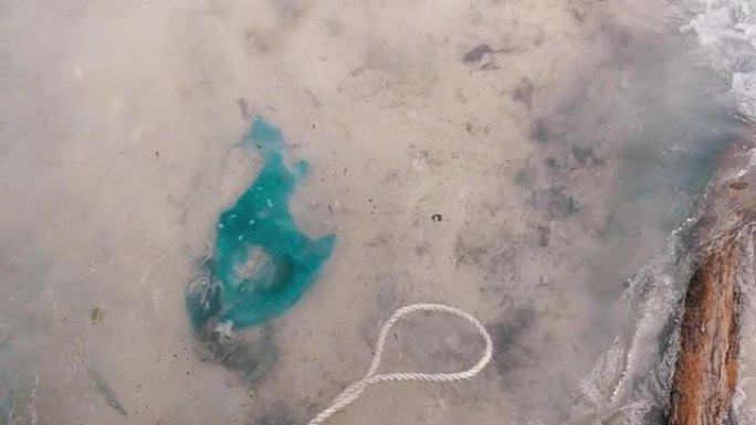 海滩上的塑料垃圾慢动作夹被海浪席卷