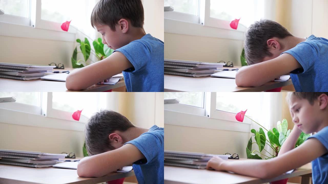 孩子累了做作业，男孩把头放在手上，不想学习