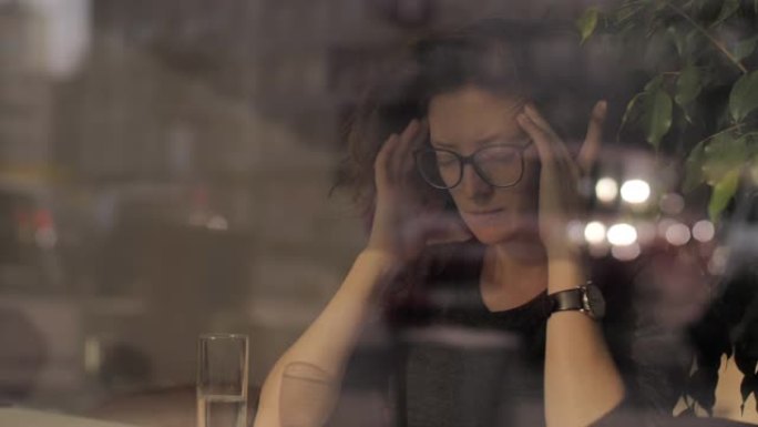 精疲力竭的女商人在办公室晚些时候头疼。过度劳累的女人在餐馆按摩头部。特写疲惫的女人自我舒缓头痛动作的