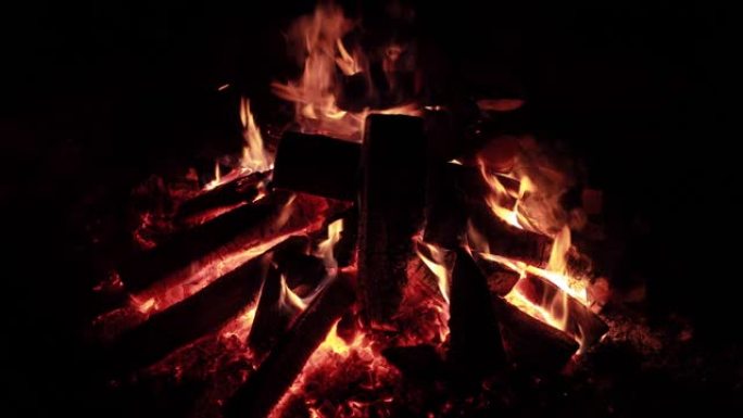晚上有柴火的大火，晚上燃烧的篝火，火花，火焰的火焰，是很多红色的木煤，壁炉，慢动作视频没有声音，蒸汽