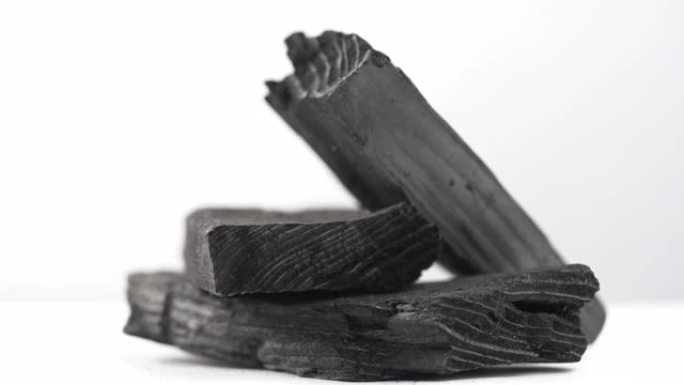 天然木炭，白色背景上的传统木炭或硬木木炭。用滑动或移动相机拍摄。4k分辨率