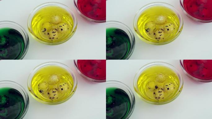 三个透明杯子，带有黄色，红色，绿色的颜色，用于彩绘复活节彩蛋