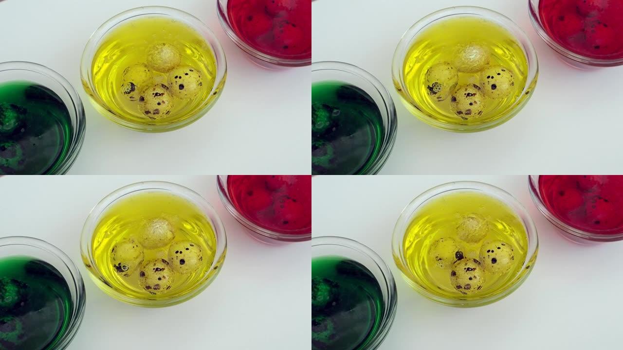 三个透明杯子，带有黄色，红色，绿色的颜色，用于彩绘复活节彩蛋