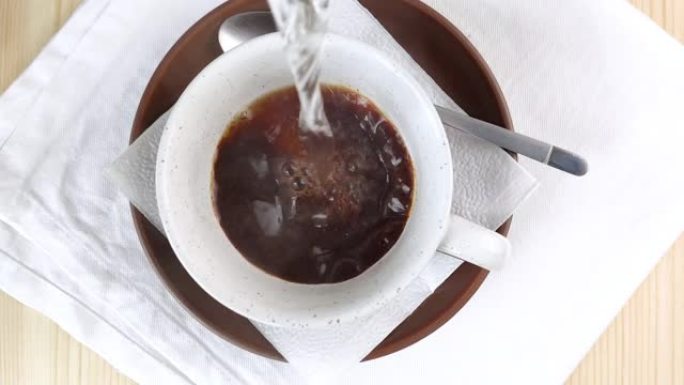 将杯中的冻干咖啡倒入沸水中。热蒸汽填充框架