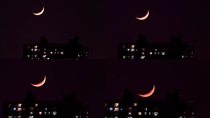 城市中的月落，新月从天空到城市建筑的延时镜头，白月到红月，4k放大视频。