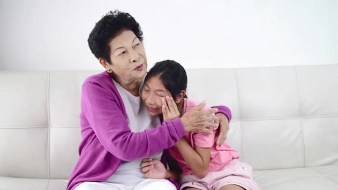 亚洲女孩在家和祖母哭泣。