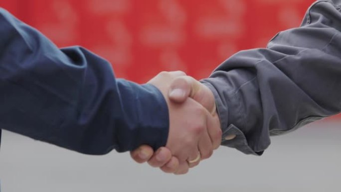 两个男人的握手特写。两个人握手。工厂握手，达成成功交易