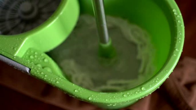 在水桶里的水中洗拖把