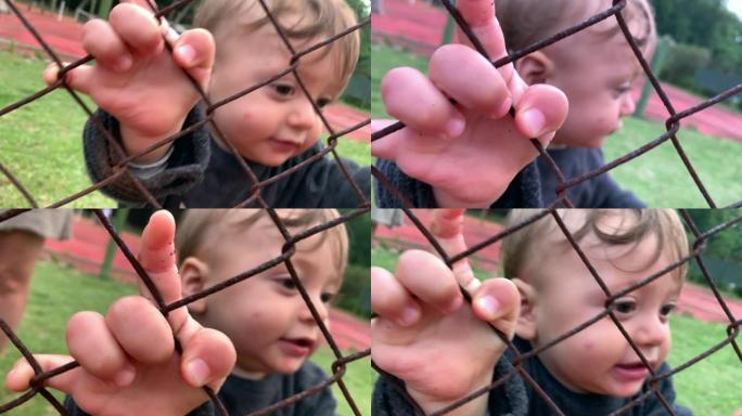 可爱的宝宝从外面看比赛欢呼，特写小手拿着栅栏