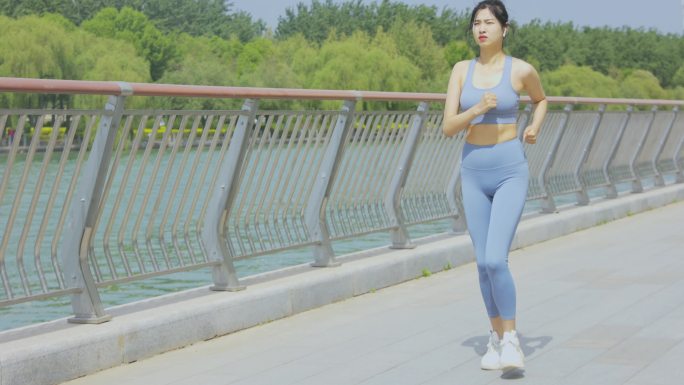 穿着运动装在公园跑步锻炼的青年女性