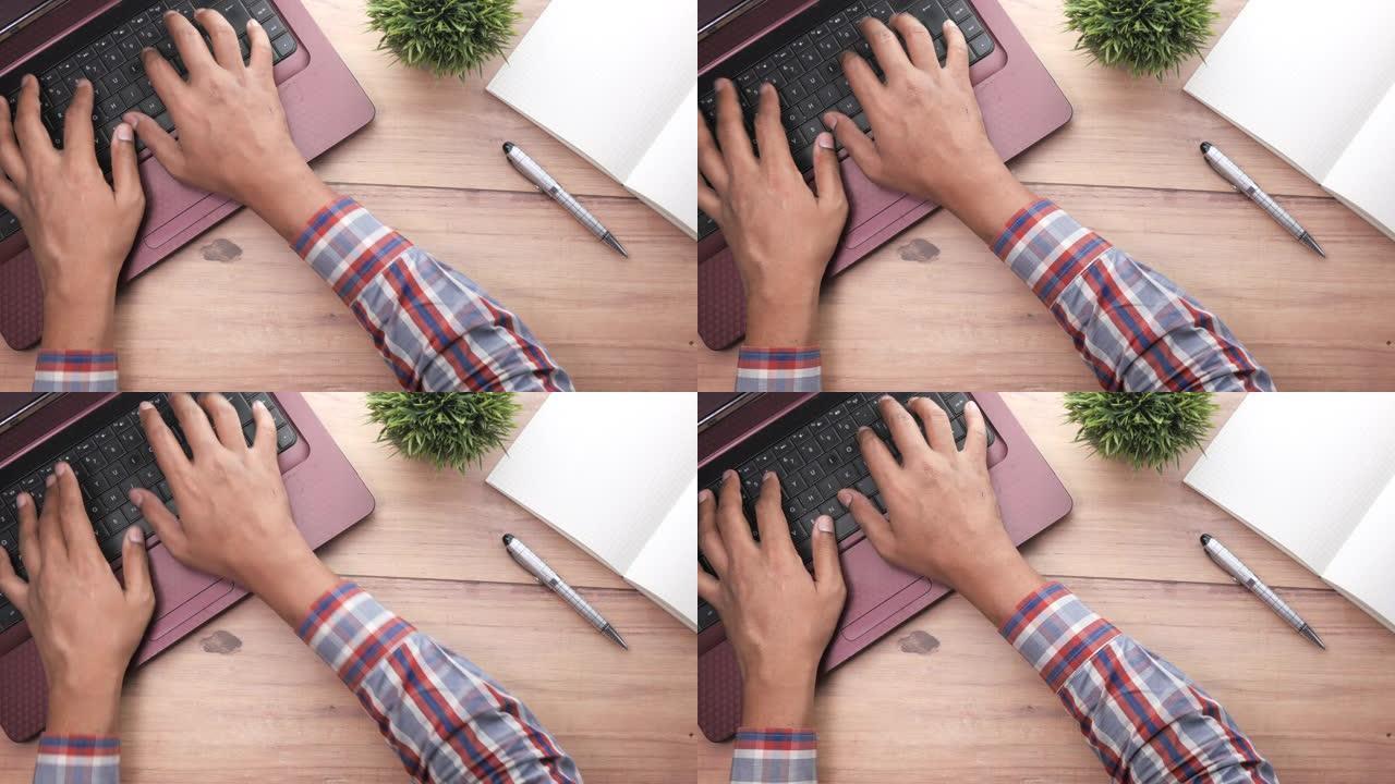 笔记本电脑上人手型打字的高角度视图