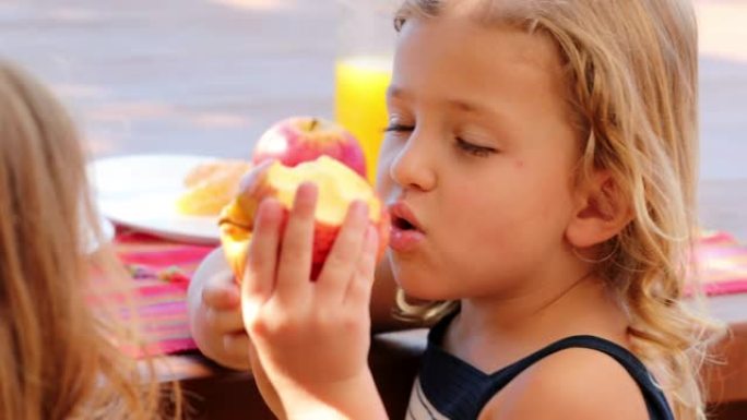 小女孩在外面咬苹果吃水果