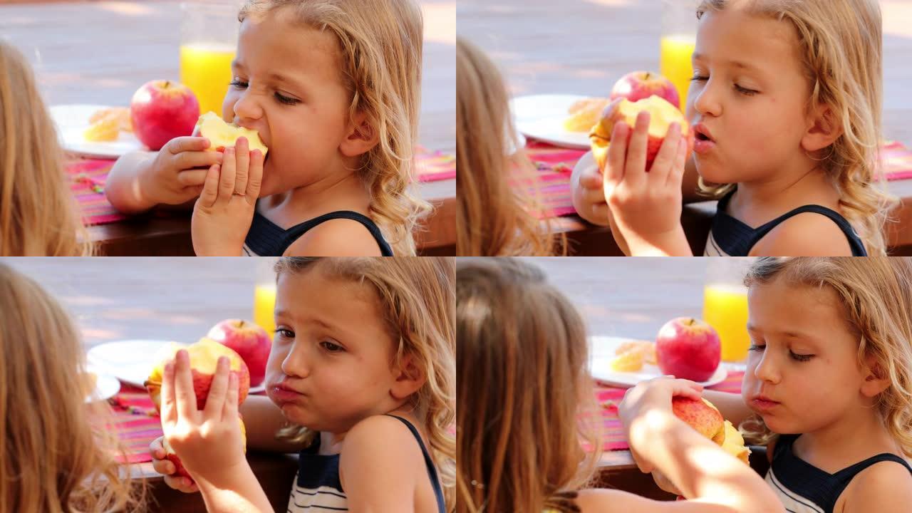 小女孩在外面咬苹果吃水果