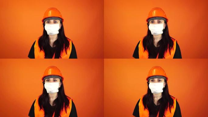 橙色背景上戴着医用面具的年轻女子的肖像。成年女性用口罩遮住脸，以保护自己免受疾病的侵害。冠状病毒流行