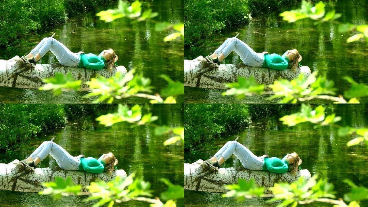 年轻女子独自在森林河上休息