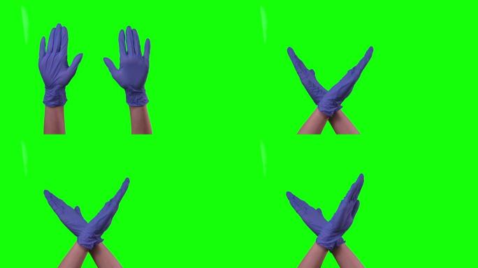 医疗实验室工作人员的手戴着蓝色防护手套，显示停车标志。绿屏。特写