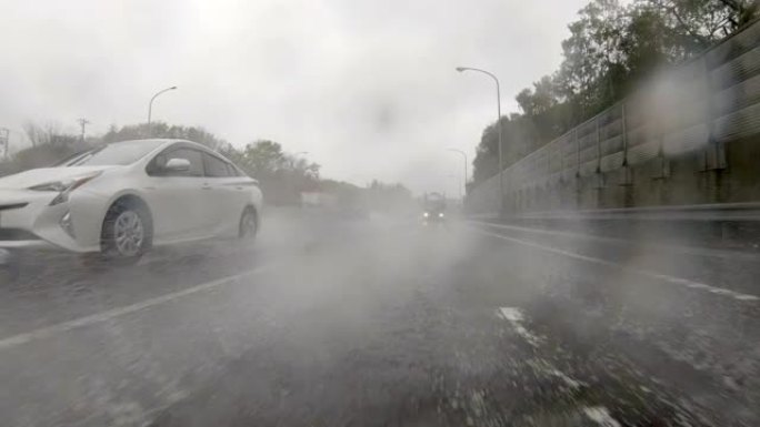 驾驶通过多雨的高速公路/后视图