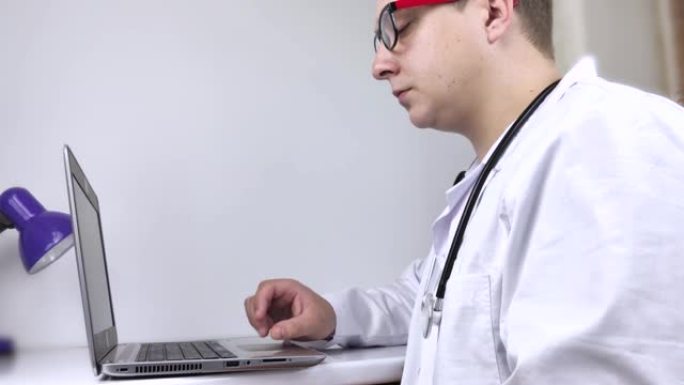 医生的工作场所。男性治疗师在电脑上工作。医学专业人员使用的现代医学和技术概念