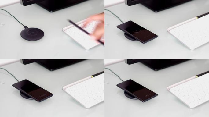 桌子上的无线充电器上正在充电的智能手机电池的特写