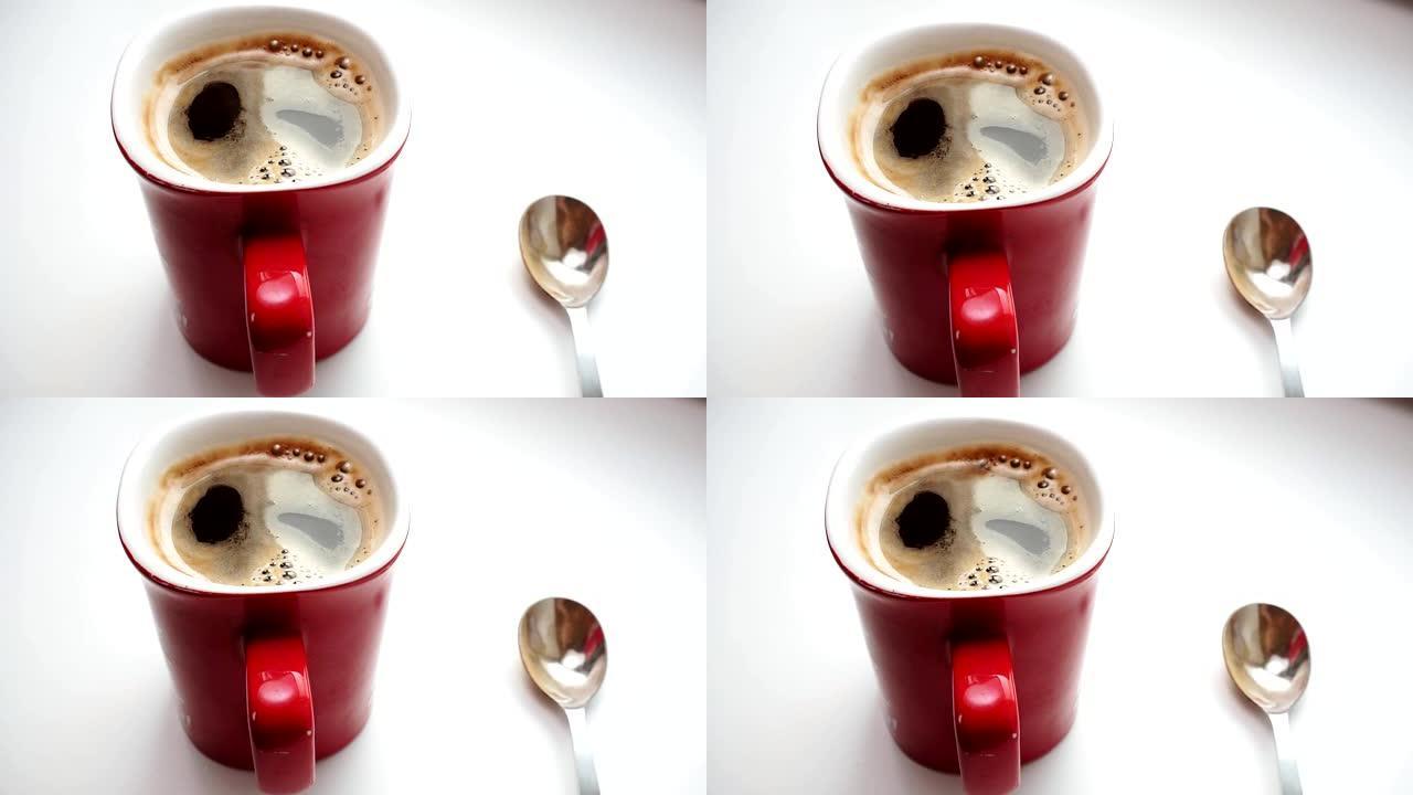 杯子里的咖啡，上面有很多气泡，特写镜头。白色背景上的现煮咖啡