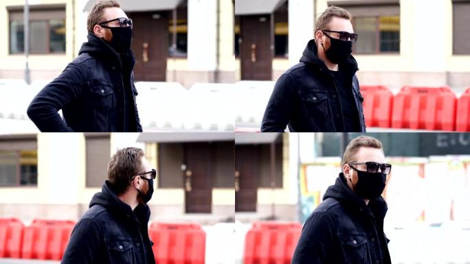 男子戴着黑色口罩，在街上行走