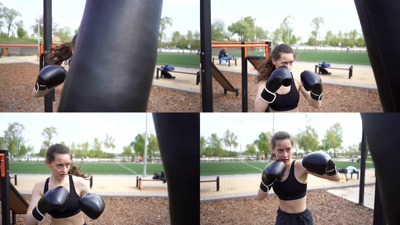 户外街头训练场用出气筒训练女拳击手。稳定的镜头，慢动作。自卫队