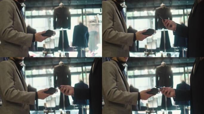 男子在男装商店用智能手机付款