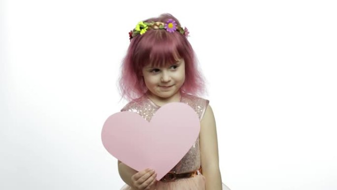 童女公主抱着粉红色的纸心。母亲节，情人节概念
