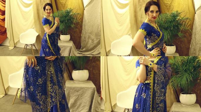 印度女人角色扮演。穿着蓝色印度纱丽连衣裙特写的年轻美女在跳舞。高清
