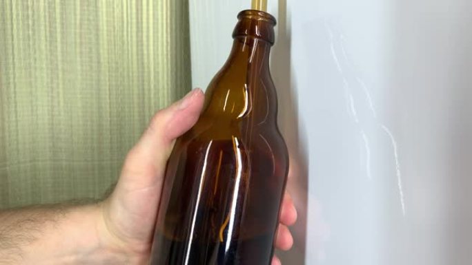 精酿啤酒厂。男性的手在家里装满棕色玻璃啤酒瓶的特写镜头。自制啤酒4k视频。