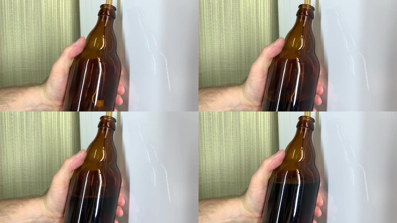精酿啤酒厂。男性的手在家里装满棕色玻璃啤酒瓶的特写镜头。自制啤酒4k视频。