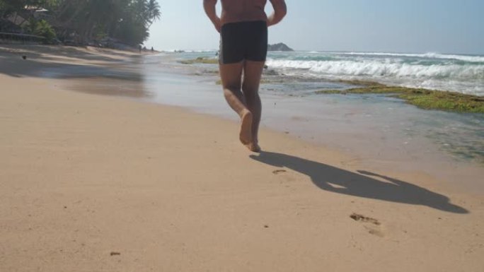 秃头男子摆脱了沿黄色海滩的超重慢跑
