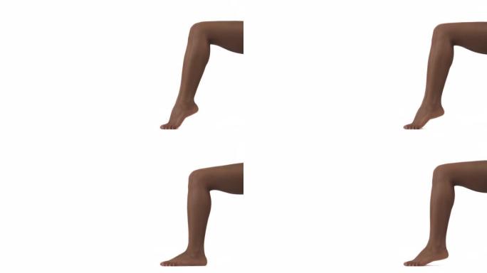 特写的苗条美丽的女性的腿。非洲妇女踮起脚尖。孤立，在白色背景上。本空间