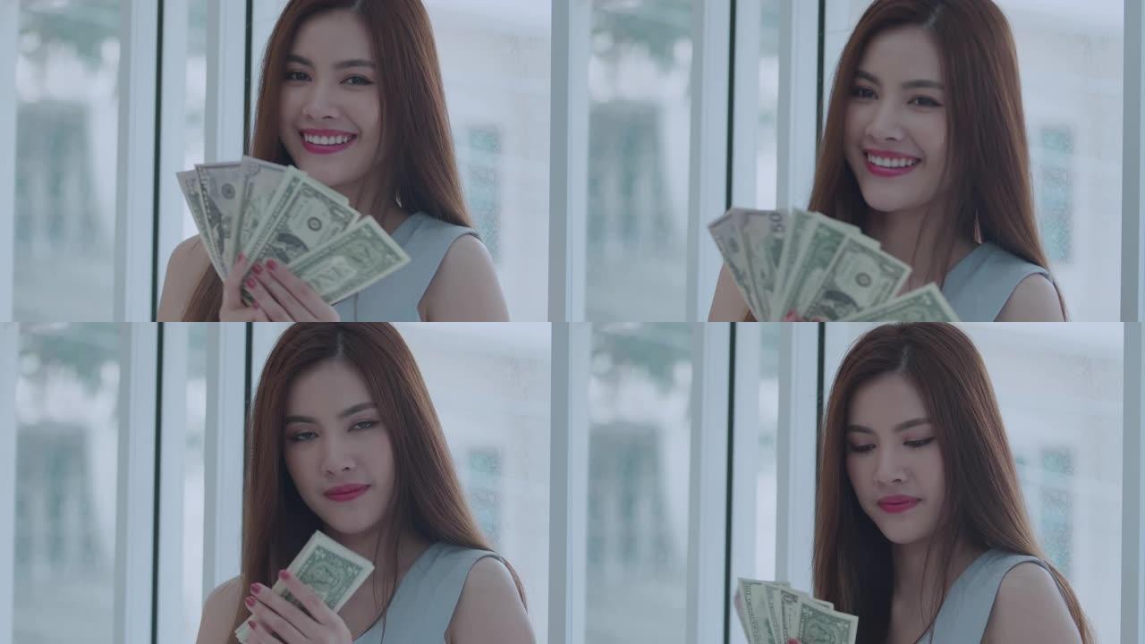 美丽的亚洲年轻女子数钱存钱。