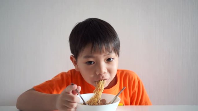 男孩吃黄色面条。