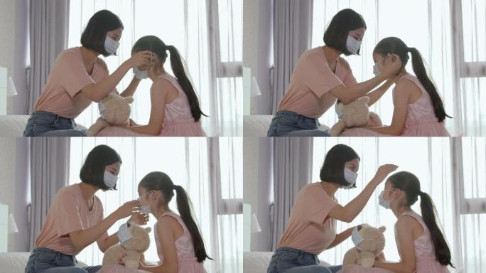 母亲帮助女儿在床上戴医用口罩