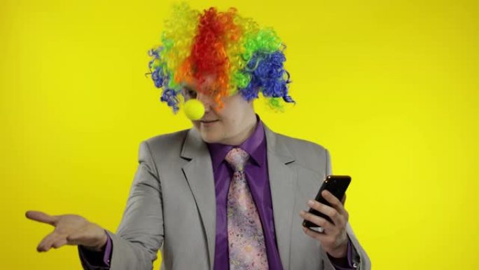 小丑商人企业家老板在使用智能手机时获得金钱收入